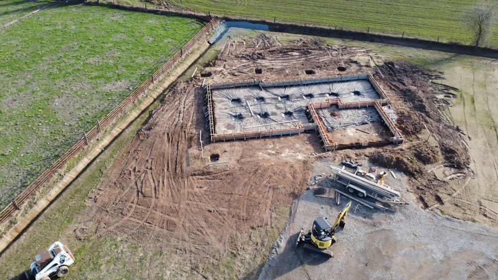 Aerial view of an excavated home site with footings formed
